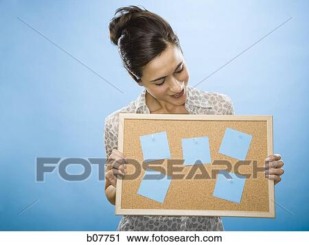 Woman holding a bulletin board with blank sticky notes View Large Photo Image Stock Image - Woman holding a bulletin board with blank sticky notes. Fotosearch