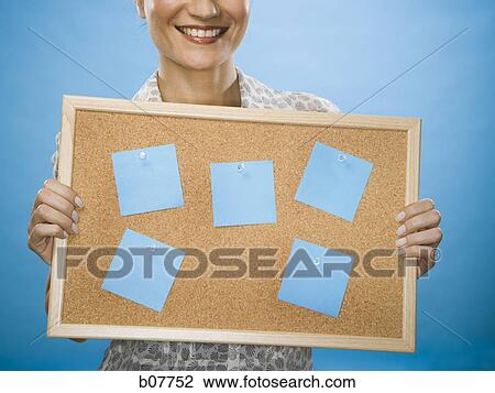 Woman holding a bulletin board with blank sticky notes View Large Photo Image Stock Image - Woman holding a bulletin board with blank sticky notes. Fotosearch