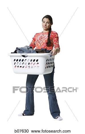 Woman holding a laundry basket of clothes View Large Photo Image Stock Image - Woman holding a laundry basket of clothes. Fotosearch