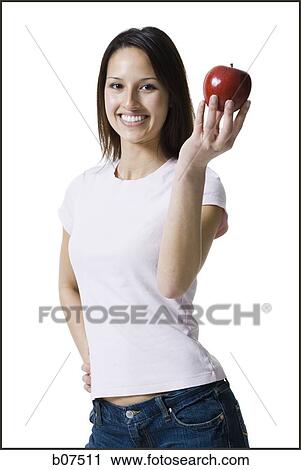 Stock Image - Woman holding a red apple. Fotosearch