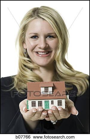 Stock Photograph - Woman holding a toy house. Fotosearch