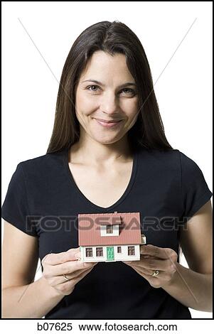 Stock Photography - Woman holding a toy house. Fotosearch
