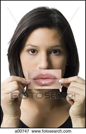 Woman holding lips cut-out in front of mouth View Large Photo Image Stock Photo - Woman holding lips cut-out in front of mouth. Fotosearch