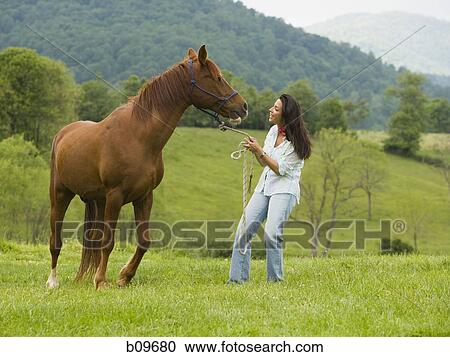 woman holding the reins of a horse View Large Photo Image Stock Image - woman holding the reins of a horse. Fotosearch