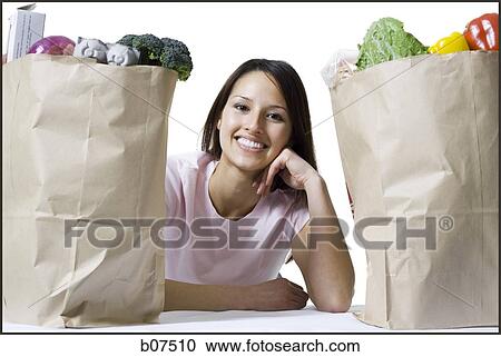 Woman in between two bags of groceries View Large Photo Image Stock Image - Woman in between two bags of groceries. Fotosearch