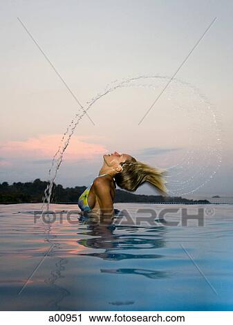 Woman in infinity pool throwing her hair back View Large Photo Image Stock Image - Woman in infinity pool throwing her hair back. Fotosearch