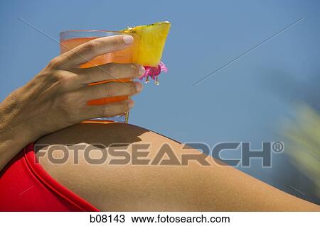 Woman in red bikini holding a cocktail beverage View Large Photo Image Stock Image - Woman in red bikini holding a cocktail beverage. Fotosearch