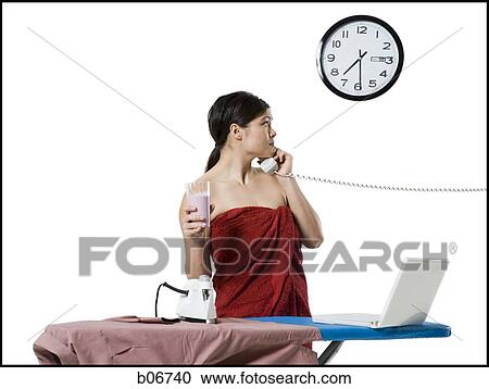 Woman ironing and working on laptop View Large Photo Image Stock Image - Woman ironing and working on laptop. Fotosearch