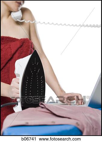Woman ironing and working on laptop View Large Photo Image Stock Image - Woman ironing and working on laptop. Fotosearch