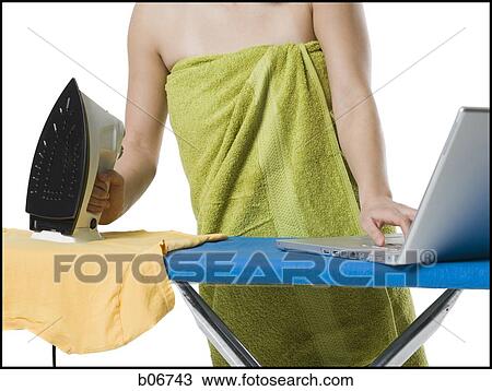 Woman ironing and working on laptop View Large Photo Image Stock Image - Woman ironing and working on laptop. Fotosearch