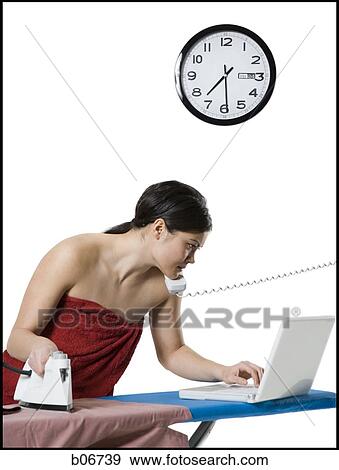 Woman ironing and working on laptop View Large Photo Image Stock Photo - Woman ironing and working on laptop. Fotosearch