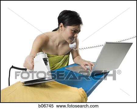 Woman ironing and working on laptop View Large Photo Image Stock Photography - Woman ironing and working on laptop. Fotosearch