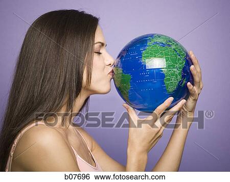Stock Photograph - Woman kissing earth globe. Fotosearch