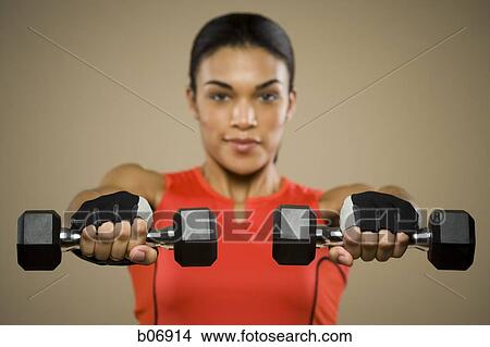 Picture - Woman lifting dumbbells. Fotosearch