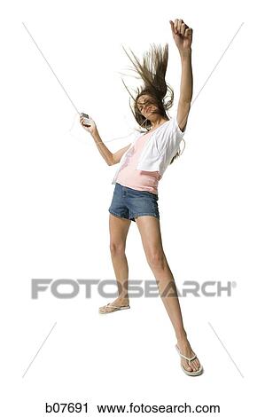 Stock Image - Woman listening to MP3 player and dancing. Fotosearch