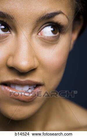Woman looking up biting lip View Large Photo Image Picture - Woman looking up biting lip. Fotosearch