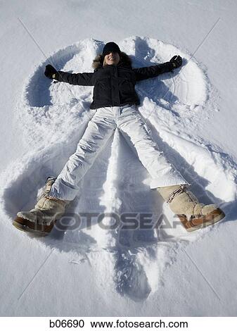 Woman making snow angel View Large Photo Image Stock Image - Woman making snow angel. Fotosearch
