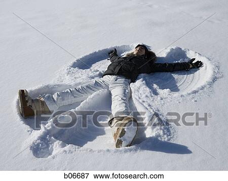Woman making snow angel View Large Photo Image Stock Photo - Woman making snow angel. Fotosearch