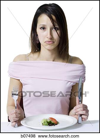 Woman on a diet eating a small salad View Large Photo Image Stock Photo - Woman on a diet eating a small salad. Fotosearch