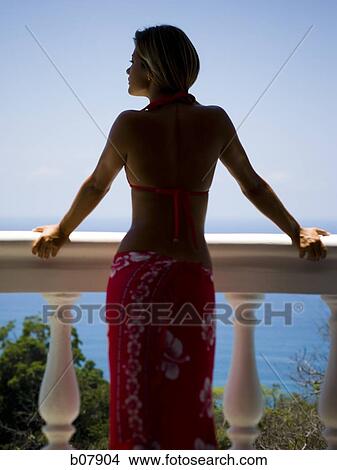 Woman on balcony overlooking ocean View Large Photo Image Picture - Woman on balcony overlooking ocean. Fotosearch