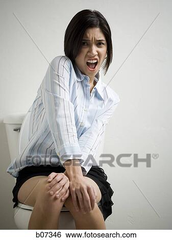 Woman on toilet with upset look View Large Photo Image Stock Photograph - Woman on toilet with upset look. Fotosearch
