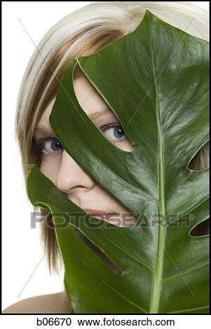 Woman peeking through plant leaf View Large Photo Image Stock Image - Woman peeking through plant leaf. Fotosearch