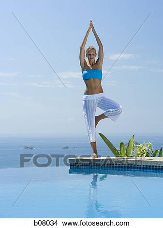 Woman performng yoga exercises by infinity pool View Large Photo Image Picture - Woman performng yoga exercises by infinity pool. Fotosearch