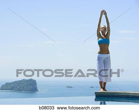 Woman performng yoga exercises by infinity pool View Large Photo Image Stock Image - Woman performng yoga exercises by infinity pool. Fotosearch