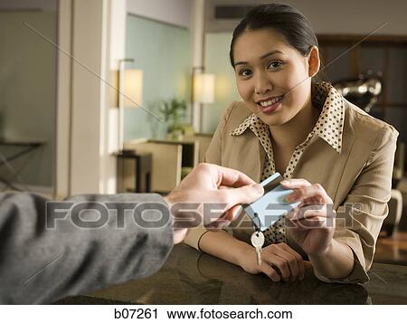 Woman providing key at check in counter View Large Photo Image Stock Image - Woman providing key at check in counter. Fotosearch