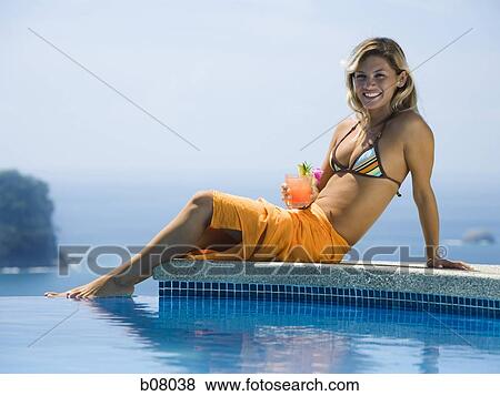 Woman relaxing by infinity pool View Large Photo Image Stock Photo - Woman relaxing by infinity pool. Fotosearch