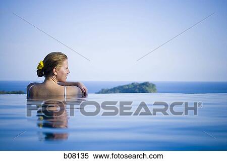 Woman relaxing in infinity pool View Large Photo Image Stock Photography - Woman relaxing in infinity pool. Fotosearch