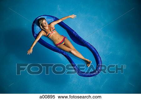 Woman relaxing on pool lounger View Large Photo Image Stock Photography - Woman relaxing on pool lounger. Fotosearch