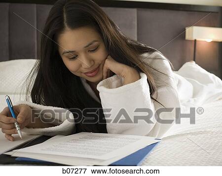 Woman reviewing document in hotel room View Large Photo Image Stock Photo - Woman reviewing document in hotel room. Fotosearch