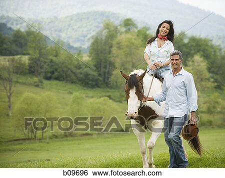 woman riding a horse with a man beside her View Large Photo Image Stock Photograph - woman riding a horse with a man beside her. Fotosearch