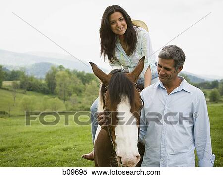 woman sitting on a horse with a man beside her View Large Photo Image Stock Photography - woman sitting on a horse with a man beside her. Fotosearch