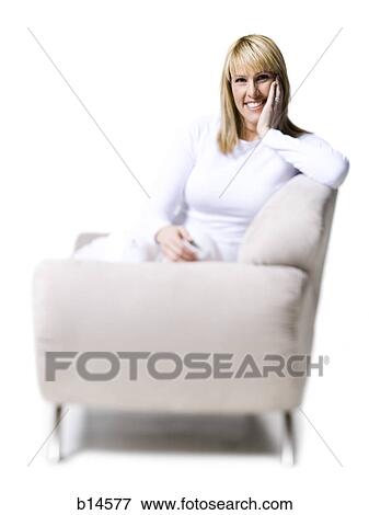 Woman sitting on armchair smiling View Large Photo Image Stock Photo - Woman sitting on armchair smiling. Fotosearch
