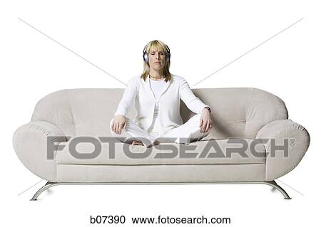 Woman sitting on couch with headphones View Large Photo Image Stock Image - Woman sitting on couch with headphones. Fotosearch