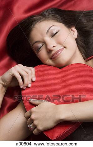 Picture - Woman sleeping with valentine heart. Fotosearch