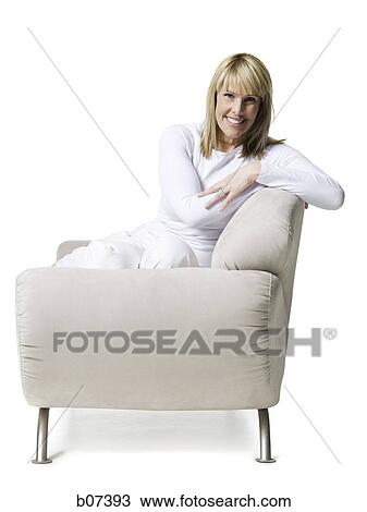 Woman smiling sitting on couch View Large Photo Image Stock Image - Woman smiling sitting on couch. Fotosearch