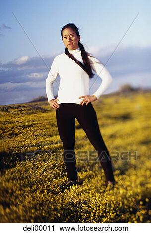 Stock Image - Woman standing in field. Fotosearch