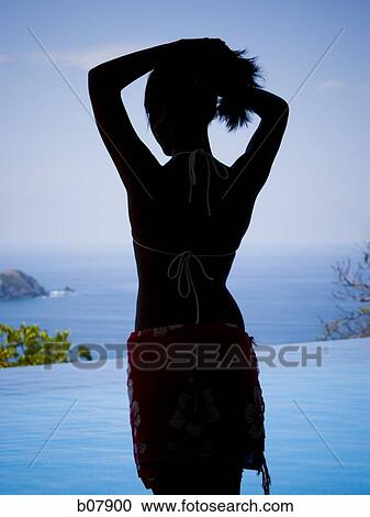 Woman standing in front of infinity pool View Large Photo Image Stock Image - Woman standing in front of infinity pool. Fotosearch