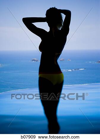Woman standing with ocean in background View Large Photo Image Stock Photo - Woman standing with ocean in background. Fotosearch