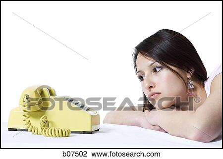 Stock Image - Woman waiting for a call on the telephone. Fotosearch