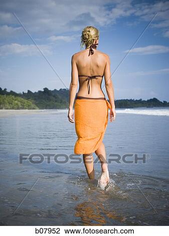Woman walking on a beach View Large Photo Image Stock Image - Woman walking on a beach. Fotosearch