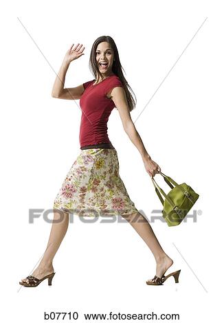 Woman walking with handbag and waving View Large Photo Image Stock Image - Woman walking with handbag and waving. Fotosearch