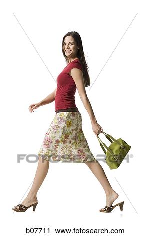 Stock Image - Woman walking with handbag. Fotosearch