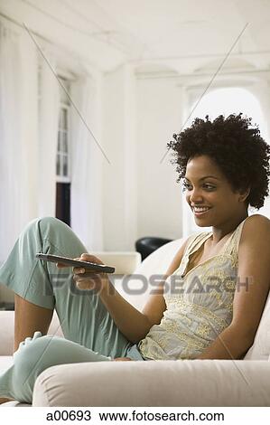 Woman with a remote control View Large Photo Image Stock Image - Woman with a remote control. Fotosearch