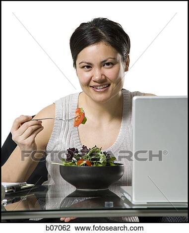 Woman with laptop eating green salad View Large Photo Image Stock Image - Woman with laptop eating green salad. Fotosearch