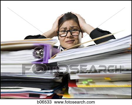 Stock Image - Woman with stack of binders and paperwork. Fotosearch