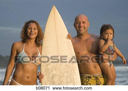 Stock Image - Woman with surfboard on beach. Fotosearch